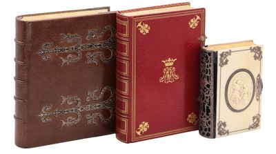 trois livres posés les uns à côté des autres sur une surface blanche
