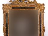 un miroir ancien avec un cadre doré et un oiseau posé dessus
