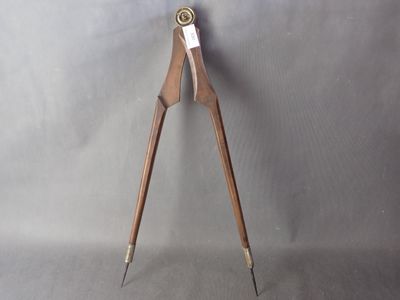 une image représentant une paire de pinces en bois et en métal sur fond gris