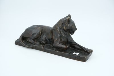 statue of a lion on a base on a white surface