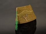 a brown hat with a green tassel on top of it