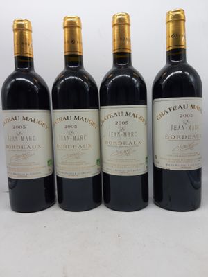 quatre bouteilles de vin sont alignées sur une surface blanche