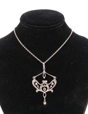 un collier avec un pendentif en argent sur un mannequin noir