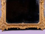 a gold frame with a mirror on it on a table