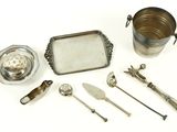 an assortment of silverplated items including a tray, spoons, and utensils