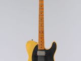une guitare électrique suspendue à une ficelle sur un mur blanc