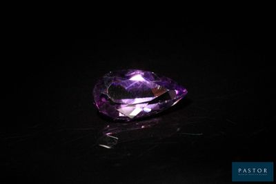 gros plan d'un diamant violet sur une surface noire