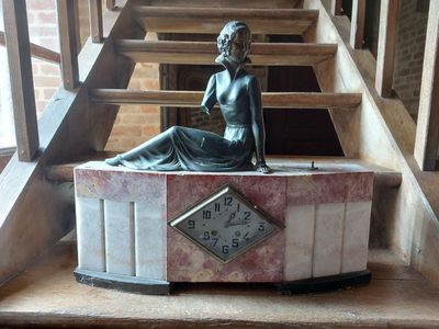 une statue de femme assise au sommet d'une horloge