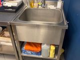 un évier en acier inoxydable dans un coin d'une salle de bains bleue