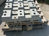 concrete blocks stacked on pallets in front of a fence