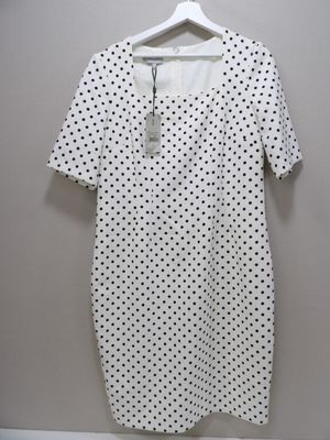 a white and black polka dot dress hanging on a hanger