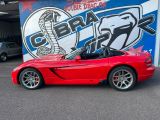 a red sports car parked in front of a garage