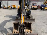 a backhoe of a construction vehicle parked in a parking lot