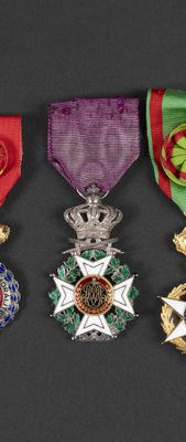 three medals are displayed on a black surface with a red ribbon