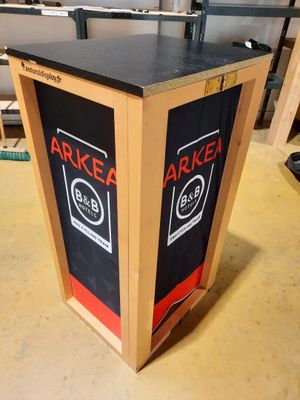 une boîte en bois sur laquelle est collée une étiquette noire et rouge