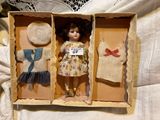 a small doll in a box with clothes on it