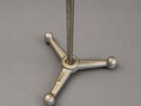 an image of a metal table with a metal base on a gray surface