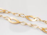 a close up of a gold chain on a white surface