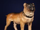 figurine représentant un chien avec un collier, sur fond bleu foncé