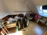 a room with a bed, a chair and a television in it