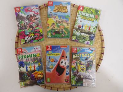 des jeux Nintendo Wii dans un panier en osier posé sur une table