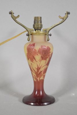 a red and yellow vase with a gold handle on a white background