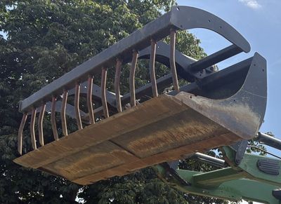 une image montrant un grand seau métallique soulevé par une grue