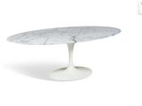 une table à manger ovale en marbre avec un piètement blanc