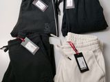 three pairs of black and white sweat pants with tags on them