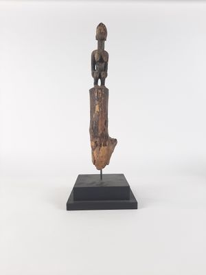 a wooden statue of a woman holding a baby on a black base