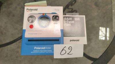 un appareil photo Polaroid posé sur une table en verre