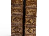 deux vieux livres sont posés côte à côte sur une surface blanche