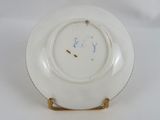 a white plate with blue writing on it on a white surface