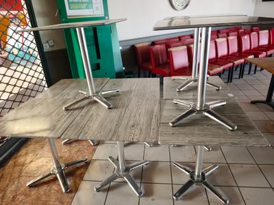 des tables et des chaises dans un restaurant où est accrochée une horloge au mur