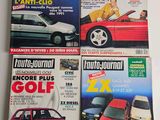four magazines of different cars on display on a white surface