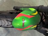 a green motorcycle with a red and yellow helmet on it