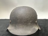 an old helmet is sitting on a black surface with a white background