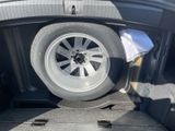 a tire in the trunk of a car with a flat tire