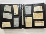 a black folder with a lot of papers and stamps on it