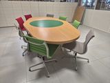 brightly colored chairs around a round conference table in a large room