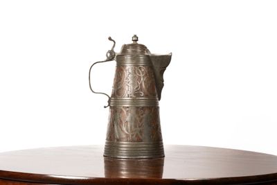 a silver coffee pot on a wooden table with a white background