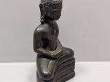 an image of a statue of a person sitting on a pile of books