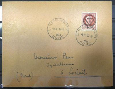 une vieille enveloppe sur laquelle sont collés deux timbres, posée sur une table