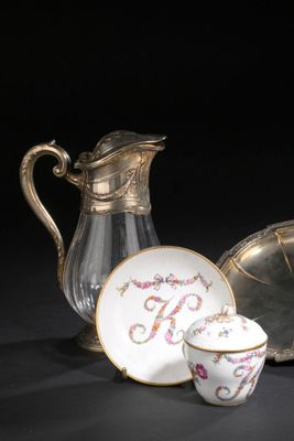 un pichet en verre et un plateau en argent avec un bol et une tasse