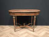 a wooden table sitting on top of a wooden floor next to a black wall