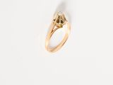 a close up of a gold ring on a white surface