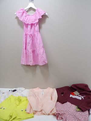 a lot of clothes hanging on the wall next to a bed
