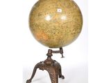 un globe antique posé sur un socle, sur fond blanc