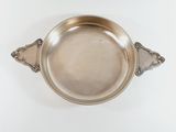 an antique silver plate with a handle on a white background