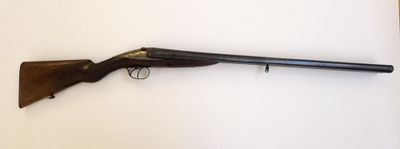 un vieux fusil posé sur une surface blanche, muni d'une crosse en bois